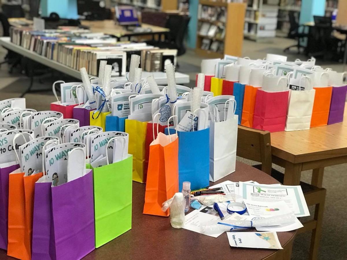 Table full of stuffed craft bags in different colors